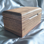 Handcrafted wooden pet cremation urn with open paw design and custom engraving option