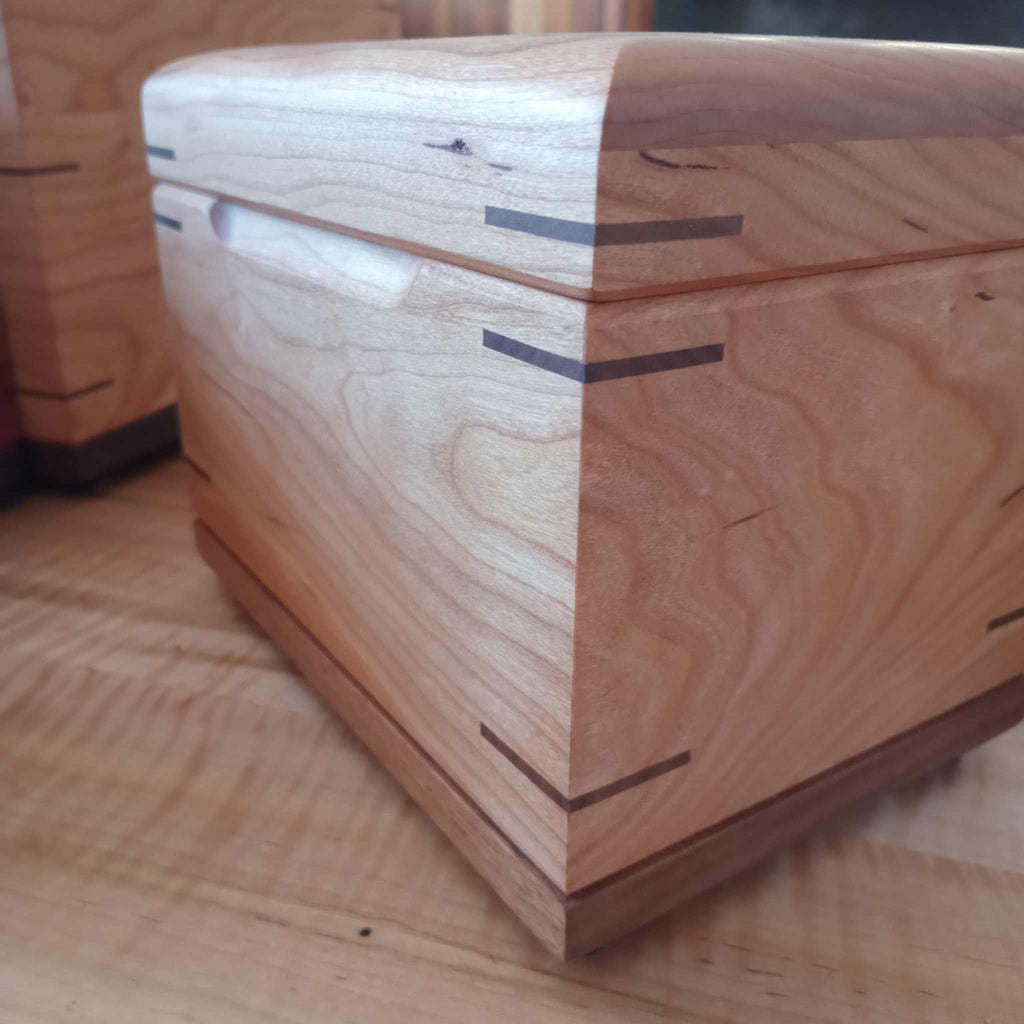 Handcrafted cremation urn for pets made of solid hardwood with open paw design and custom engraving options