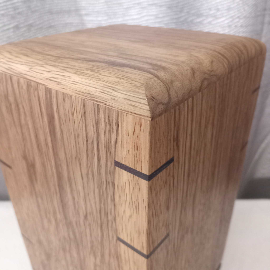 Handcrafted memorial urn made from solid hardwood with a natural finish and secure closure