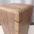 Handcrafted memorial urn made from solid hardwood with a natural finish and secure closure