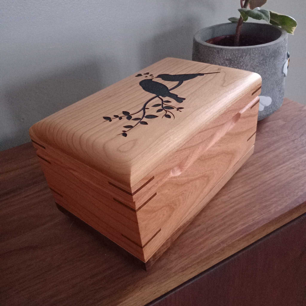 Handcrafted cremation urn for pets made from solid hardwood with custom engraving and natural wood grain design