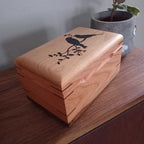Handcrafted cremation urn for pets made from solid hardwood with custom engraving and natural wood grain design