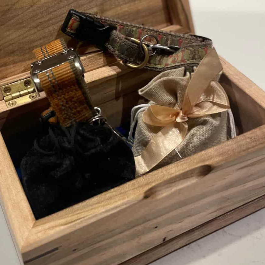 Handcrafted cremation urn for pets with open paw design made from solid hardwood