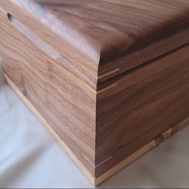 Handmade custom wooden urn shaped like a treasure chest, crafted from solid hardwood in Canada
